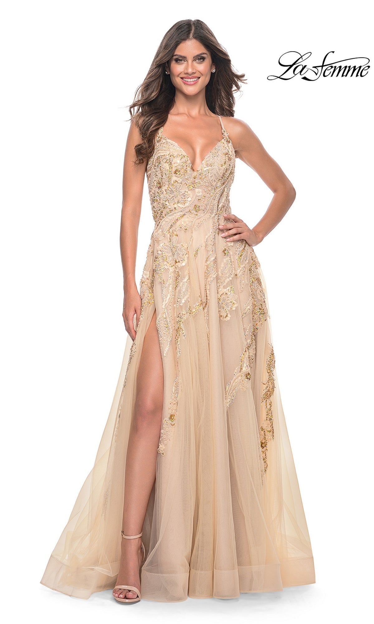 A woman in a La Femme Sequin-Lace Long A-Line Prom Dress 32032, featuring champagne sequins, a thigh-high slit, and spaghetti straps, smiles while standing against a white background.